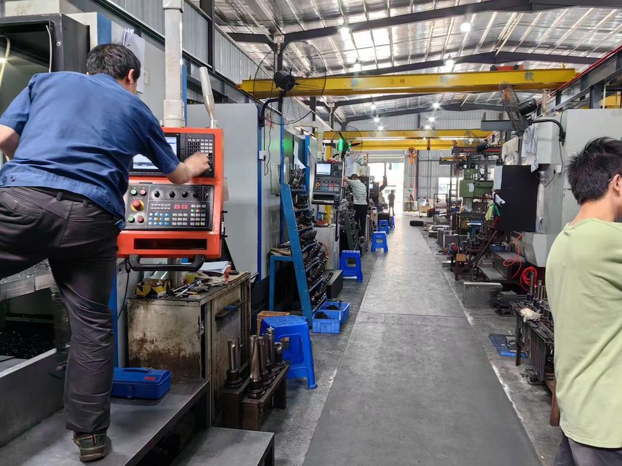 Machinists working between CNC centres in the machining bay