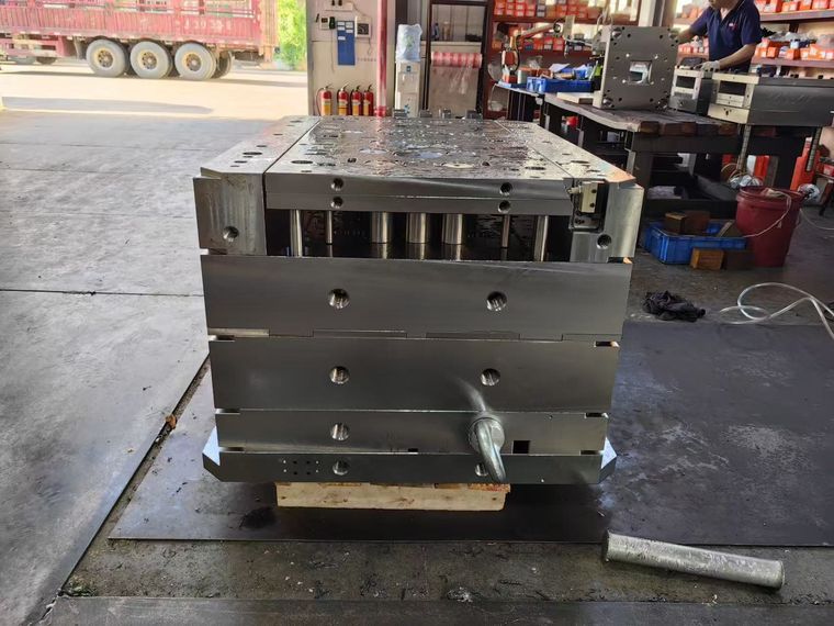 Injection mold base with guide pillars and ejector holes seen from the side